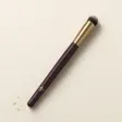A small, dense, domed concealer brush.