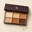 An open palette of six cream concealers from ivory to deep brown.