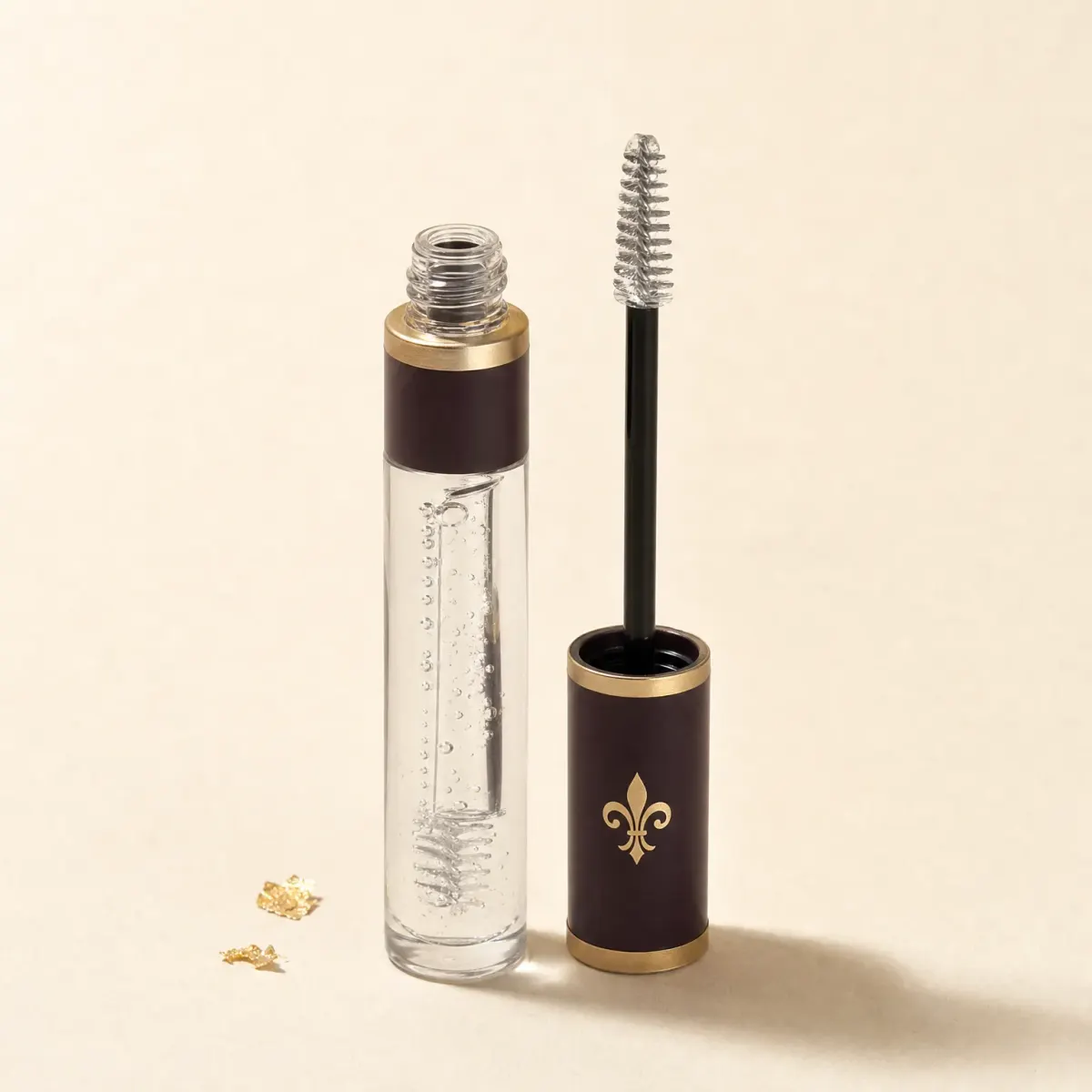 A slim clear tube of transparent brow gel with its wand beside it.