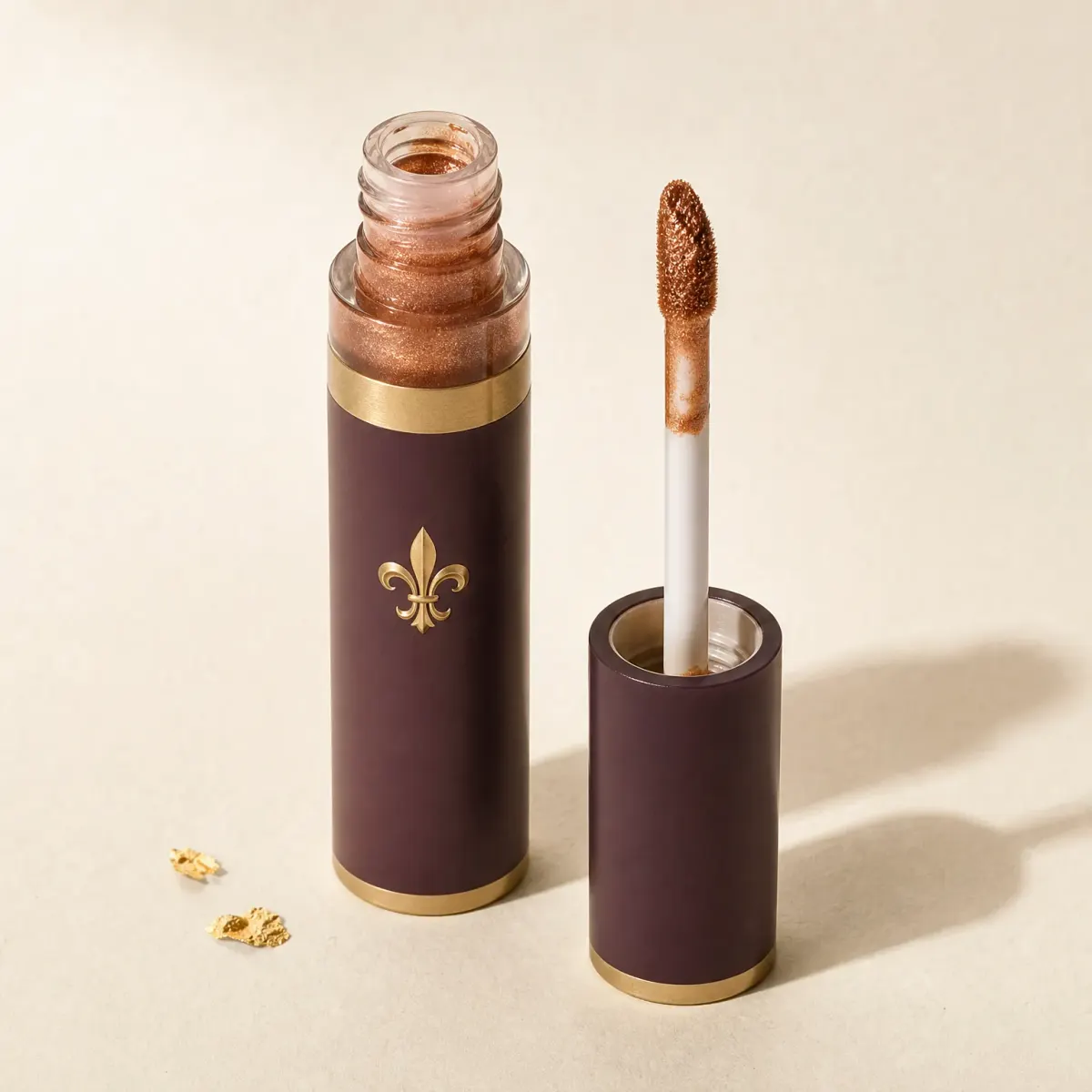 A small tube of copper liquid eyeshadow with its wand beside it.