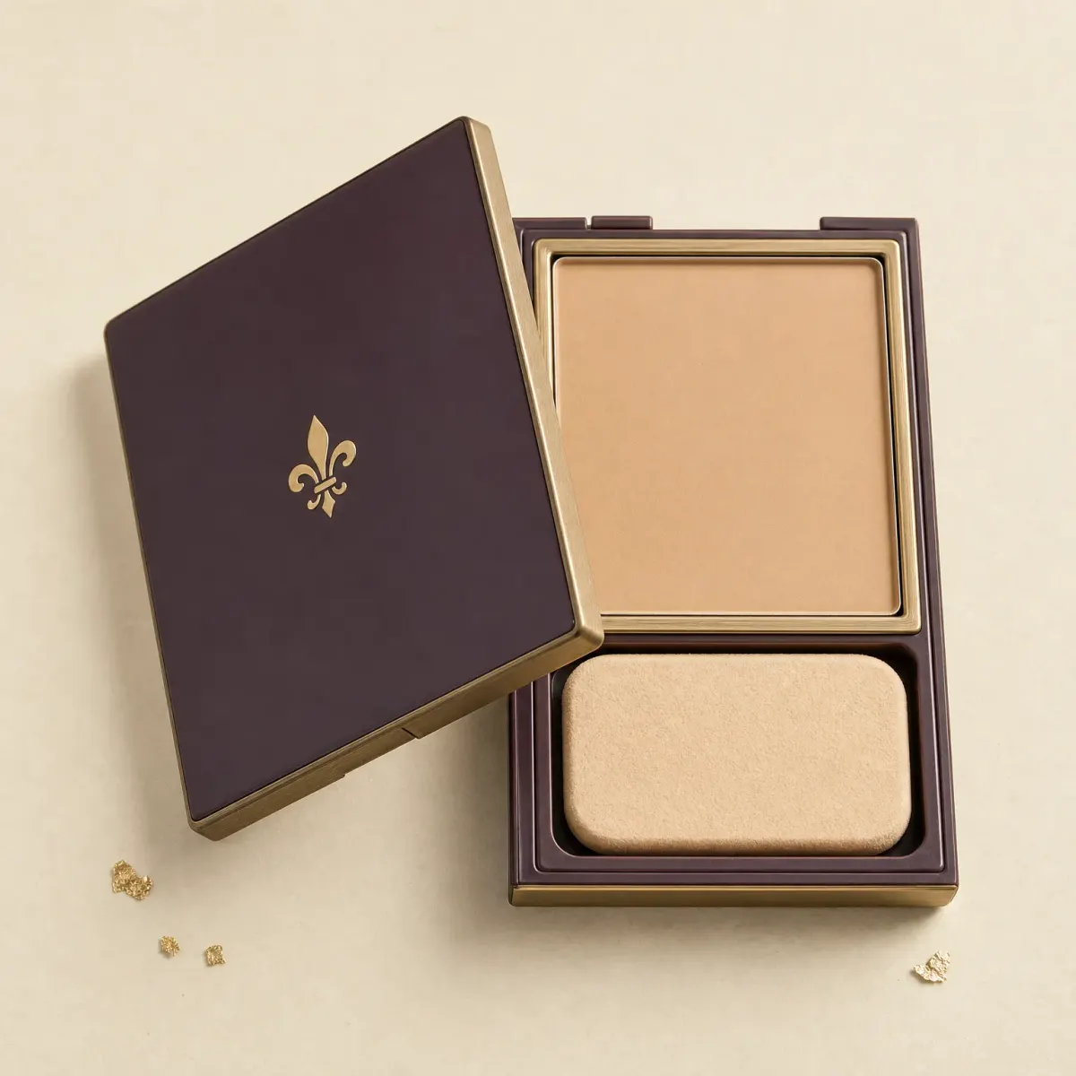 An open square compact of pressed foundation with a sponge in a separate tray.