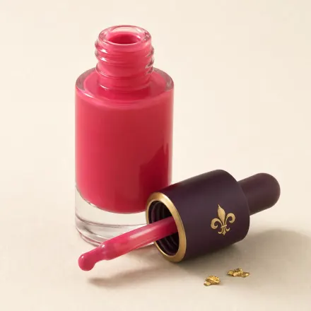 A small dropper bottle of berry-pink liquid blush.