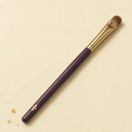 A small, flat, tongue-shaped concealer brush.