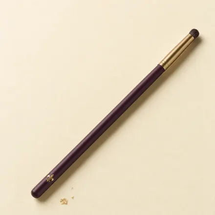 A slim eye brush ending in a tiny, dense, domed smudger tuft.
