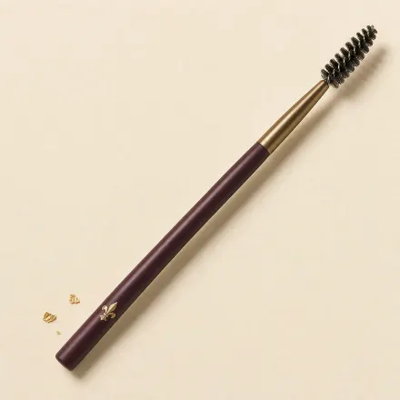 A spoolie with a small spiral bristle head on a slim handle.