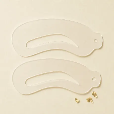 A pair of translucent brow stencils.