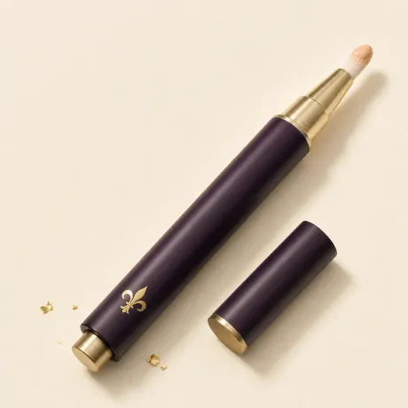 A slim click pen of brightening concealer with a brush tip.