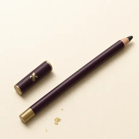 Illustration: A slim sharpened black kohl pencil with its cap beside it.