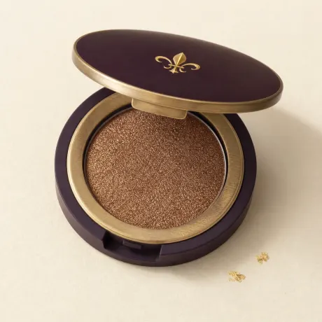 Illustration: An open single-pan compact of shimmering bronze eyeshadow.