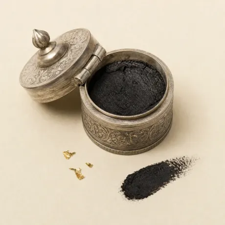 Illustration: A small open silver box of soft black kajal paste.