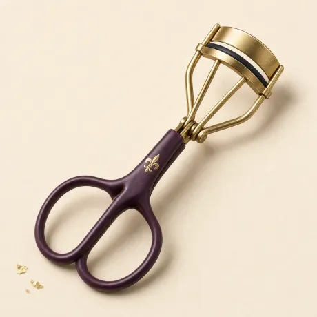 Illustration: A metal eyelash curler with scissor finger loops.
